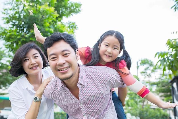 Ritratto felice della famiglia asiatica in giardino.