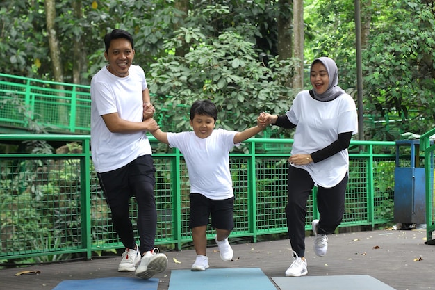 Asian family having fun exercising sport together at the park.