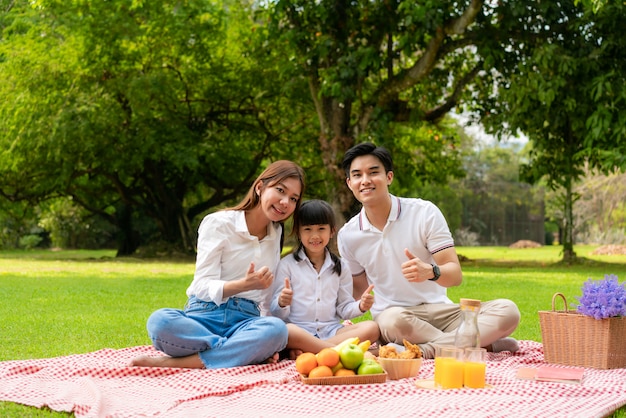 Famiglia asiatica che ha un picnic nel parco