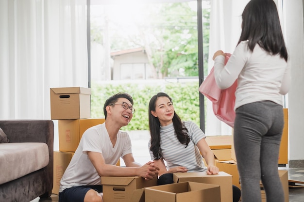 Asian family moving to new home house and unpacking boxes