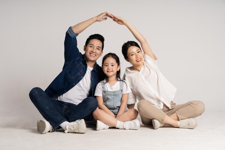 Photo 색 배경 에 포즈 를 취하고 있는 아시아 가족 의 초상화