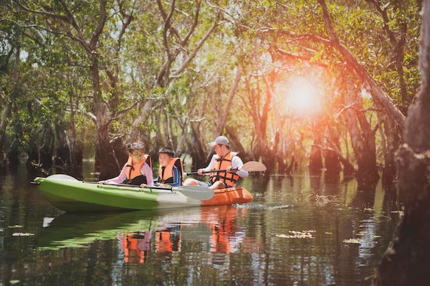 Asian family sailing sea kayak in mangrove forest