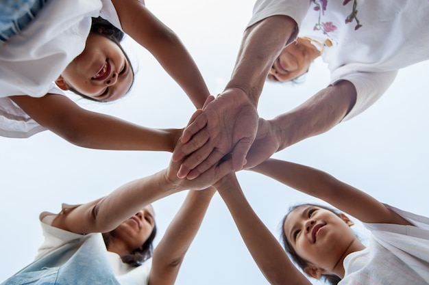 Asian family standing hands support together. Family generation join hands showing unity and teamwork.