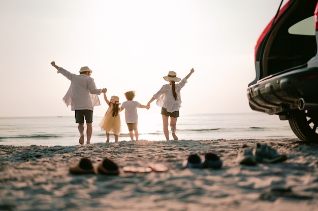 Vacanze in famiglia asiatiche genitori di famiglia felici che tengono in braccio i bambini che volano nel cielo Foto Premium