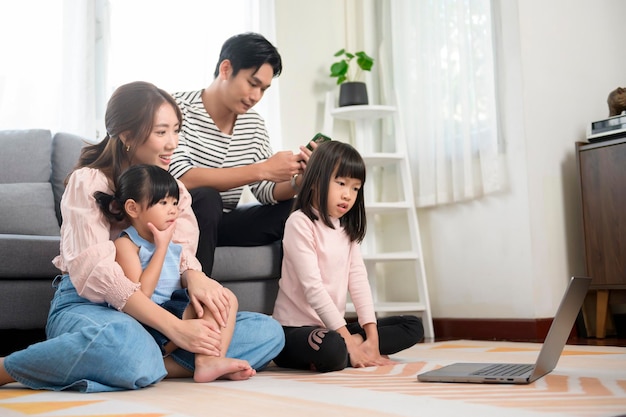 Asian family with children using laptop computer at home