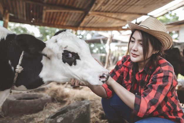 アジアの農家は、都市の外の田舎の酪農場で働きます牛を持つ若者