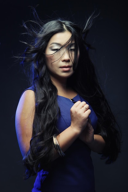 Donna asiatica alla moda con il vento tra i capelli