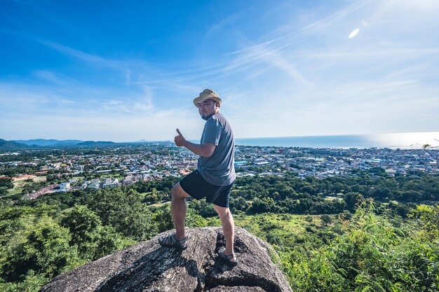 Asian fat man stand on the rock at Khao hin lek fai view pointKhao Hin Lek Fai is a place to see a spectacular view of the entire townAlso know as khao radar in local people