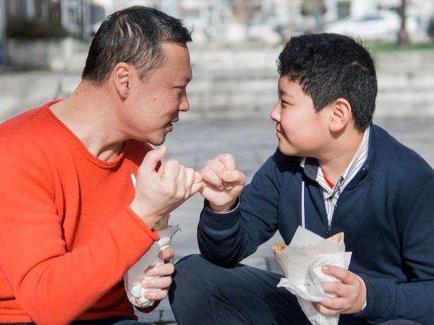Азиатский отец и сын мизинец обещают
