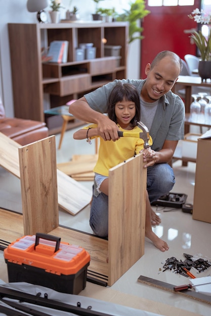 Photo asian father and daughter assembling new furniture at their home
