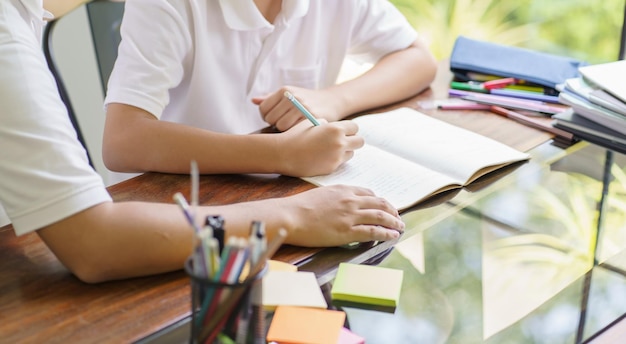 Photo asian father helps son to do her homework for the schoolxachild study together homeschooling concept getting homework help from father