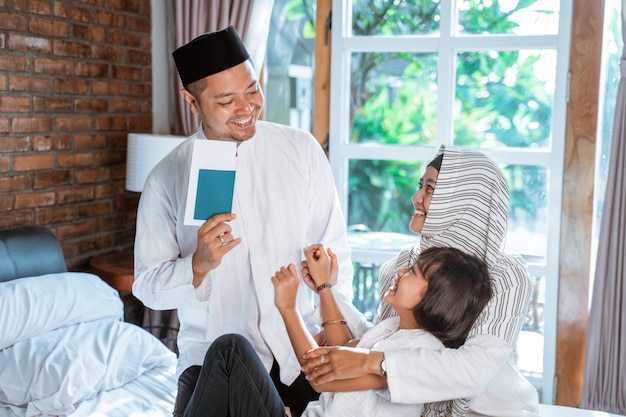 Asian father holding passport when family members prepare suitcase for carried when mudik