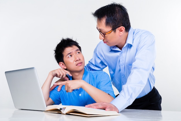 Asian father and son learning at home for school