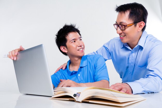 Asian father and son learning at home for school