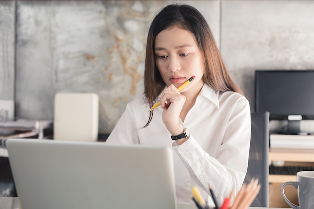 アジアの女性がオフィスで働くことを強調している