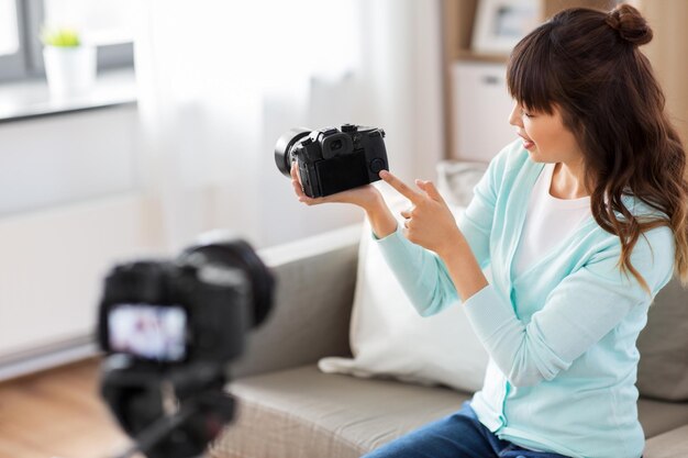 写真 アジアの女性ブロガーがカメラでビデオを録音している