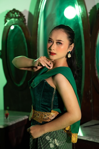 Foto una ballerina asiatica con un costume da ballo verde e un corpo sexy posa molto agile mentre balla