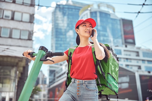 Asian female delivering takeaway food to customer outdoors