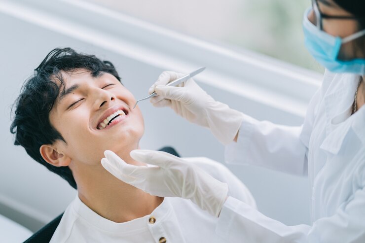 Photo 환자의 치아를 검사하는 아시아 여성 의사