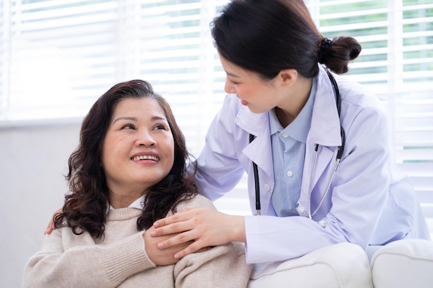 Asian female doctor examining an elderly woman at home