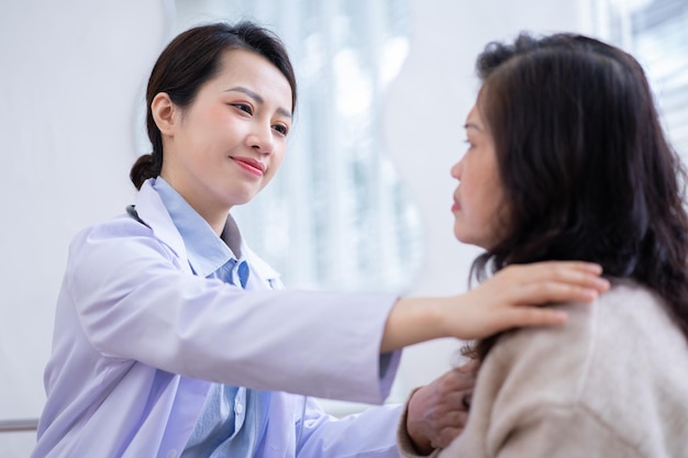 Asian female doctor examining an elderly woman at home