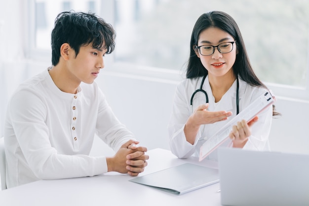 Asian female doctor is reporting the health status to the patient