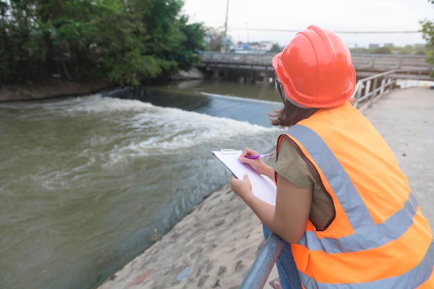 Asian Female engineering working xA at sewage treatment plantMarine biologist analysing water test resultsWorld environment day concept