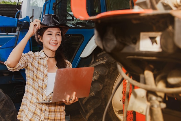 Foto l'agricoltore femminile asiatico controlla i servizi di manutenzione e l'uso negli orti agricoli.