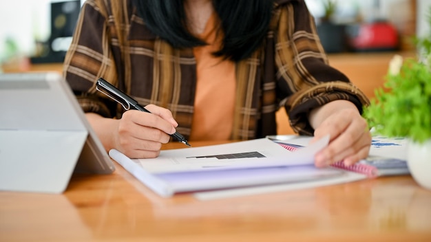 Photo an asian female in flannel shirt working on documents or paperwork cropped image