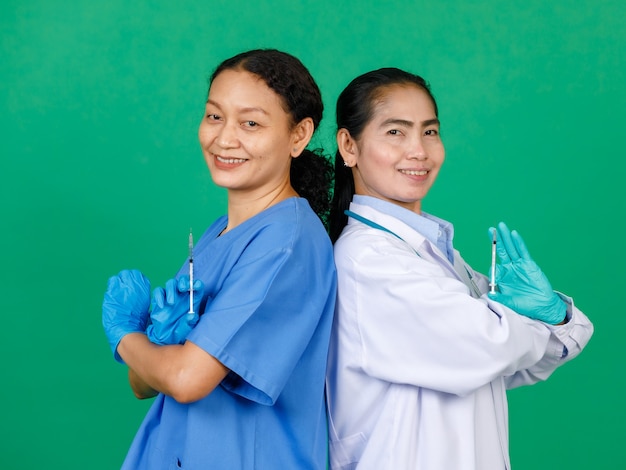 주사를 준비하는 주사기와 코비드 19 백신을 들고 흰 가운을 입은 아시아 여성 간호사와 의사. Covid 19 예방 접종에 대한 개념입니다.