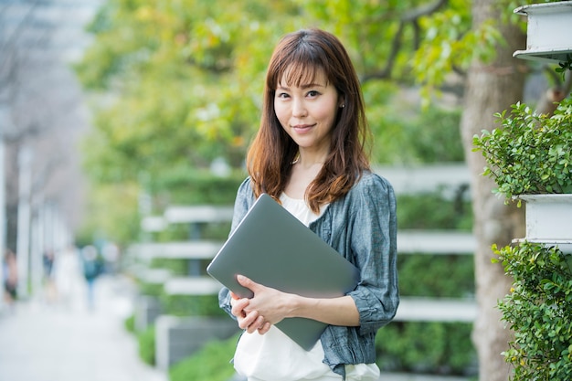 Asian female office worker with laptop