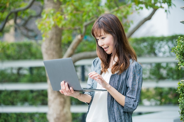 Asian female office worker with laptop