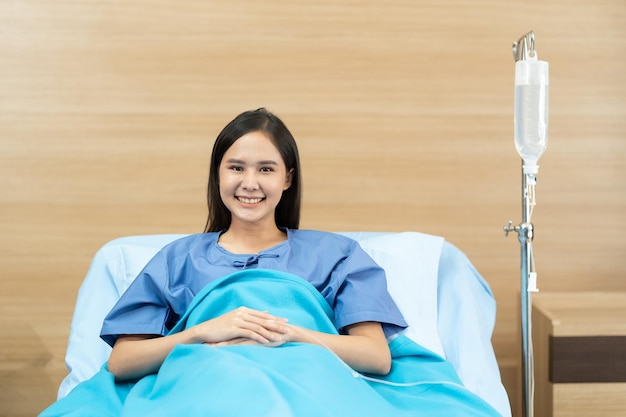 Photo asian female patient with happiness lying on bed in hospital