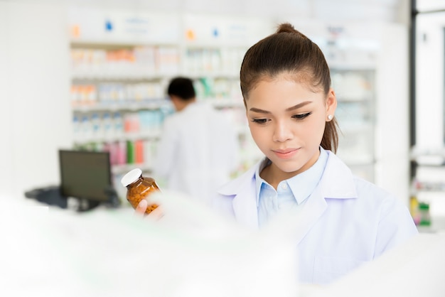 Foto farmacista femminile asiatico in farmacia o farmacia