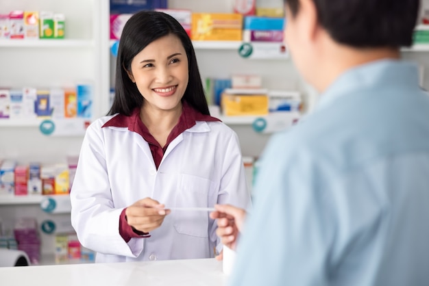 Asian female pharmacist receives a paper list of drug from male patients