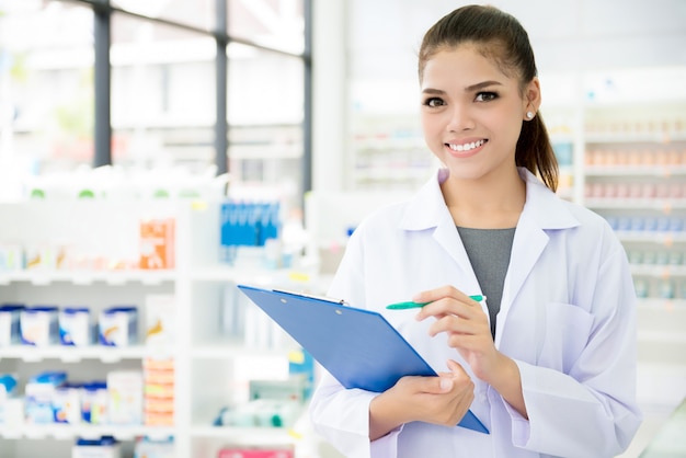 Asian female pharmacist working in chemist shop or pharmacy