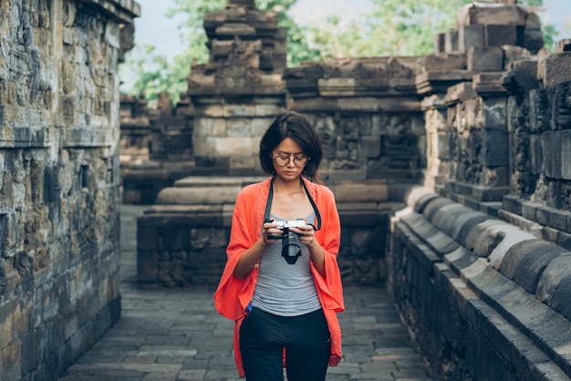 アジアの女性一人旅行者がインドネシア、ジャワのボロブドゥール寺院で写真古代建築物を撮る