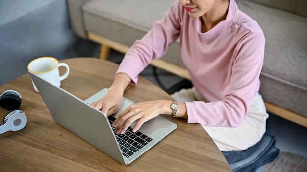 Asian female spending her free time at home using laptop searching information on internet