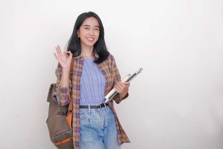 Photo アジアの女性学生がバックパックとラップトップを背負って大学に行く準備をしています