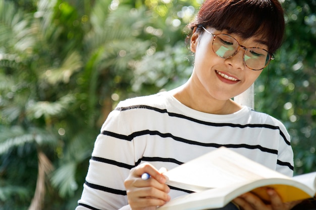 Азиатская студентка делает домашнее задание с усердием, сидя в университете.