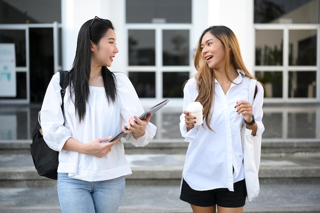 아시아 여대생이 수업시간에 반 친구와 걷고 이야기를 나누다
