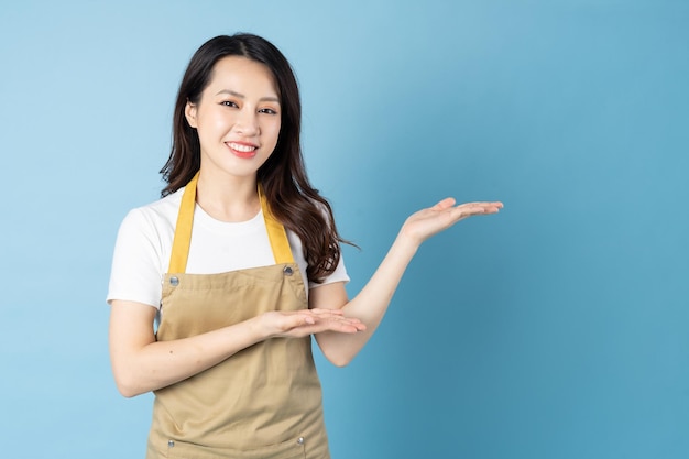 Asian female waitress portrait, isolated on blue background
