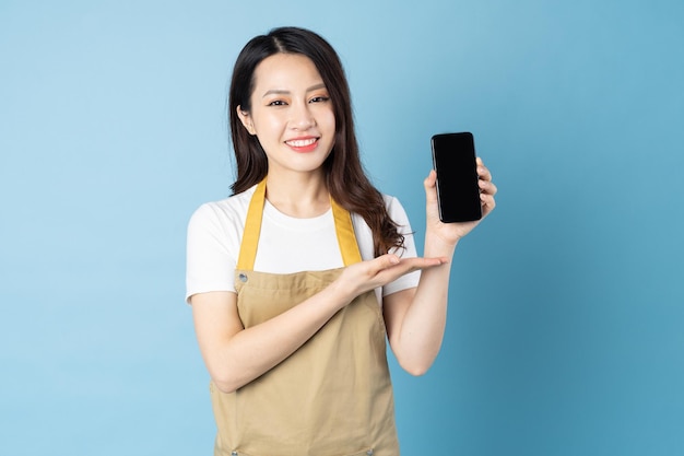 Asian female waitress portrait, isolated on blue background