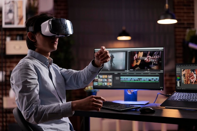 Cineasti asiatici che modificano video multimediali sul computer, utilizzando occhiali vr e app software. creazione di filmati o montaggi con color grading sull'interfaccia utente di produzione multimediale.