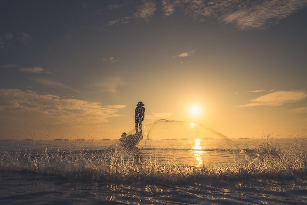 Foto pescatori asiatici sulla pesca in barca nella campagna del lago thailandia