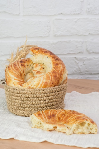 Photo asian flatbread in a basket on wooden table on white bricks background top view