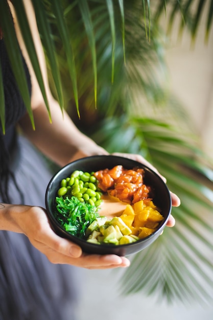 Asian food. Bowl with salmon, avocado, peas and seaweed. Food photography