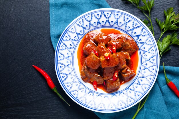 アジア料理のコンセプトSambalGoreng Daging Beef in red curry Chili and Spice Paste on black background with copy space