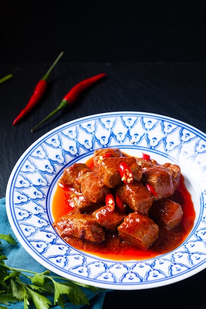 アジア料理のコンセプトSambalGoreng Daging Beef in red curry Chili and Spice Paste on black background with copy space