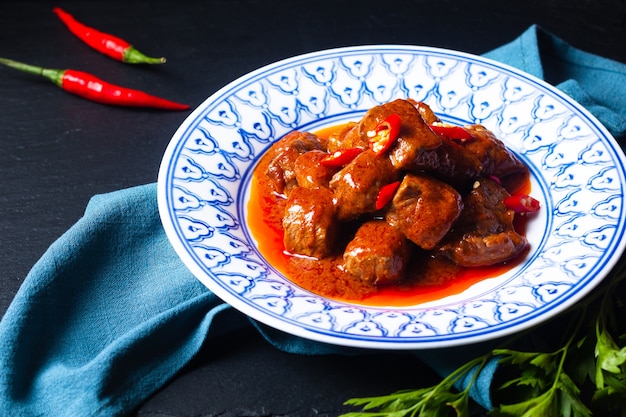 アジア料理のコンセプトSambalGoreng Daging Beef in red curry Chili and Spice Paste on black background with copy space